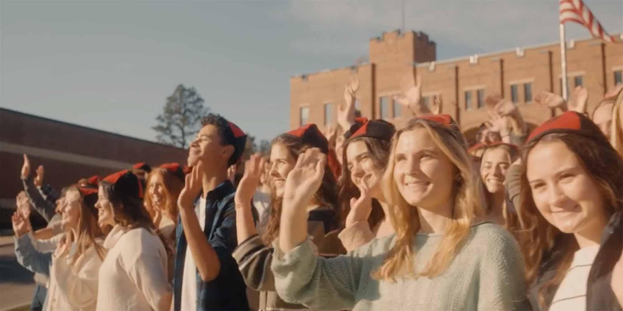 Students in beanies waving